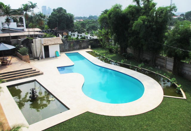 A pool in a backyard of a luxurious house.