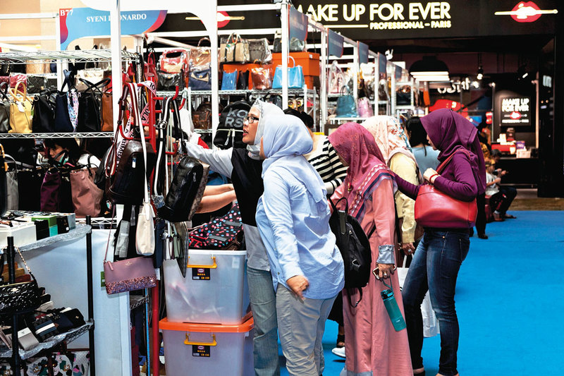 Women looking at bags sold at Irresistible Bazaar