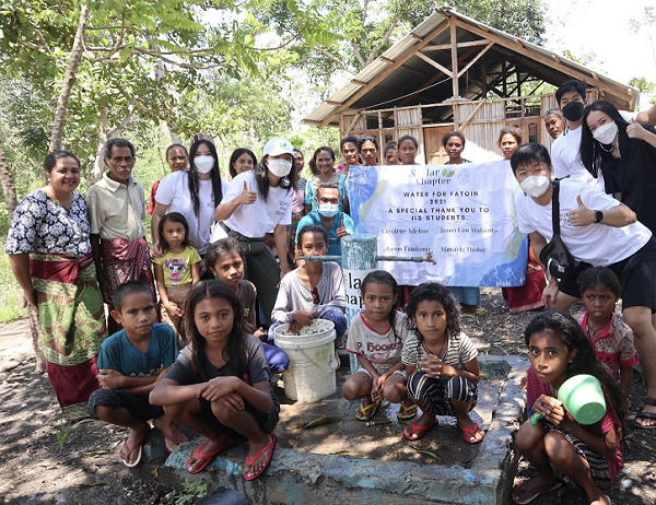 Jakarta Intercultural School students and members of Solar Chapter pose for a picture with children of Fatoin village in East Nusa Tenggara